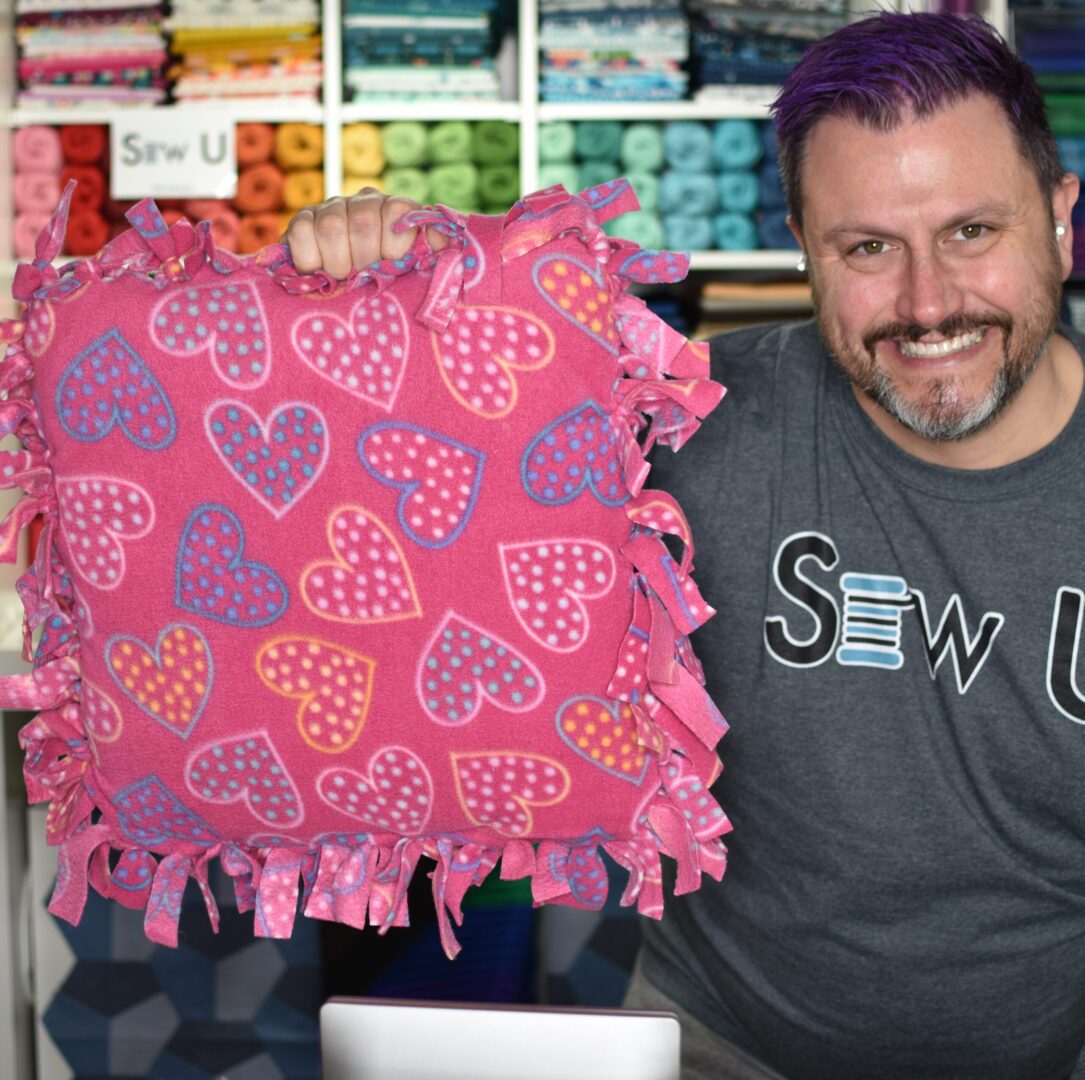 Mathew Boudreaux holding a pink pillow